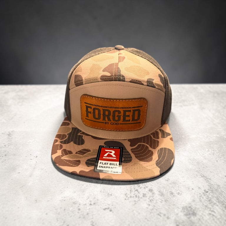 Tan camouflage snapback cap with Forged leather patch and Flat Bill Snapback label on white surface