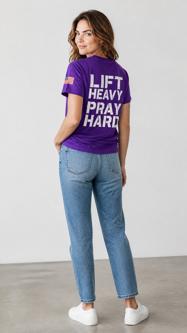 Woman wearing a purple Lift Heavy Pray Hard graphic tee with an American flag