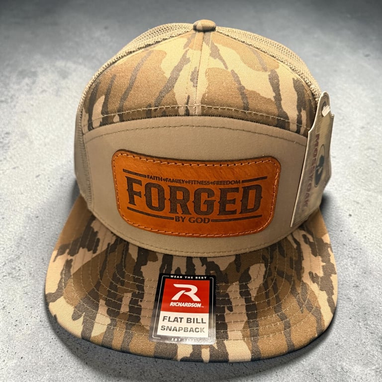 Tan and brown camouflage snapback cap with orange FORGED patch on front, displaying flat bill tag